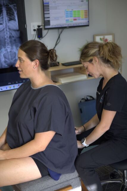 a woman sitting back to back with a woman in black shirt